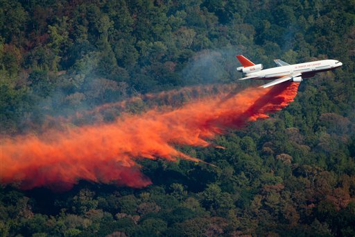 A DC-10 airplane drops retardant near Magnolia, Montgomery, Texas, to help fight a large wildfire almost like ones in Bastrop Texas (AP Photo/Houston Chronicle, Smiley N. Pool)