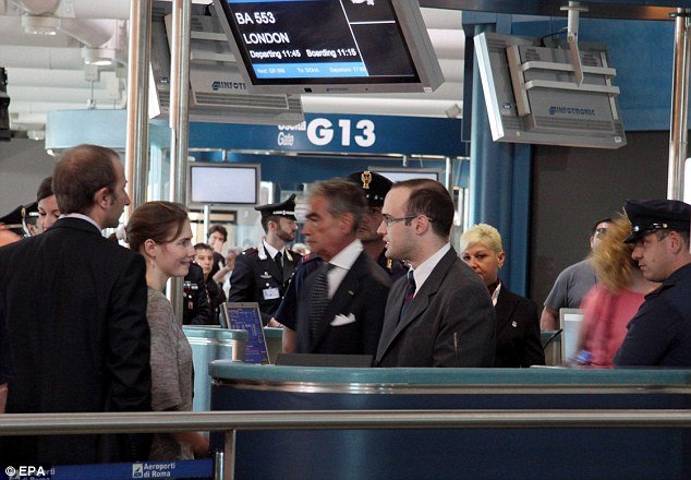Amanda Knox talks to British Airways staff as she prepares to put baggage on to the flight