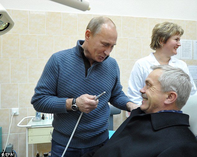 Russian Prime Minister Vladimir Putin took a picture pretending to give Yevgeny Savchenko, Governor of Belgorod, an oral hygiene check at a dentistry center during a campaign visit