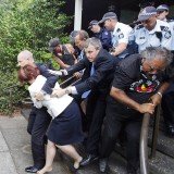 About 50 police escorted PM Julia Gillard and Tony Abbott from Canberra's Lobby restaurant after it was surrounded by some 200 supporters of the city's Aboriginal Tent Embassy