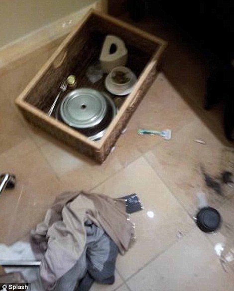 A tray can be seen on the floor of the hotel bathroom which is said to have contained a turkey sandwich and jalapenos, a Gilette razor, glass of water and items of clothing are also strewn on the floor