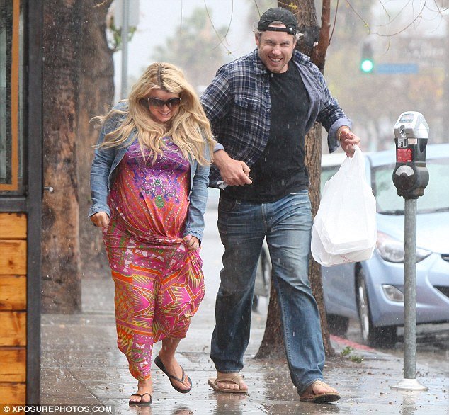 Heavily pregnant Jessica Simpson was caught in a downpour with fiancé Eric Johnson while leaving the Boneyard Bistro in LA