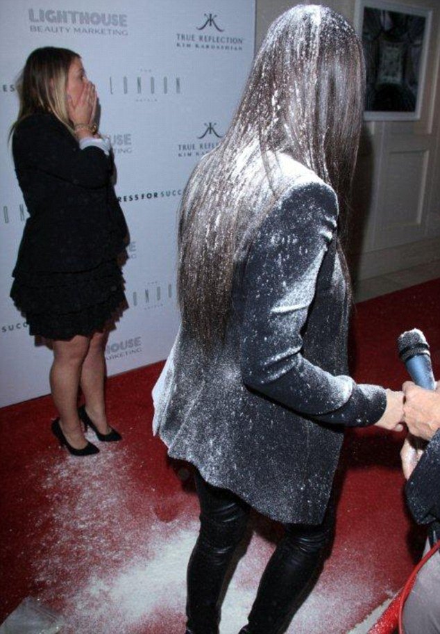 Kim Kardashian was covered in flour after an unidentified Asian woman pelted her at the launch of True Reflection at The London Hotel in West Hollywood