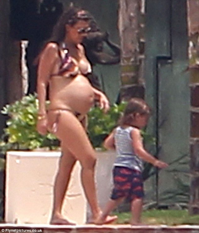 Kourtney Kardashian revealed her baby bump by slipping into a bikini on holiday