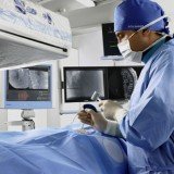Prostatic Artery Embolization can be done under a local anaesthetic using a catheter (a small plastic tube) to inject tiny plastic particles no bigger than a grain of sand into the blood vessels that feed the swollen prostate