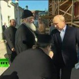 Vladimir Putin reacts awkwardly as a priest bows to kiss his hand during a visit to country's northern Valaam Island