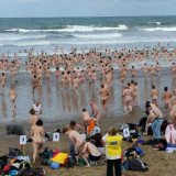 Hundreds of swimmers have braved the cold of the Northumberland coast in an attempt at a record-breaking skinny dip