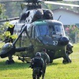 Malaysian troops have launched an assault on armed members of a Filipino clan in an ongoing conflict that has left at least 27 dead on Borneo island