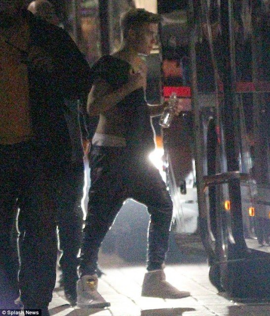 Justin Bieber ditched his top and was seen walking back to his tour bus with his shirt slung over his shoulder in Frankfurt on Thursday