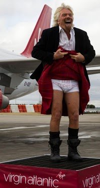 Richard Branson lifted up his kilt to the watching crowd to reveal pants bearing the slogan “stiff competition” as he stepped off the first Virgin plane at Edinburgh airport from Heathrow