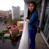 Geraldine Bautista on the 15th floor balcony from which she tried unsuccessfully to save Tom Stilwell who fell 13 floors outside the Volt apartment block in downtown