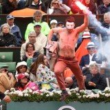 Masked protester waving a lit flare ran onto the court at the men's final of the French Open tennis in Paris