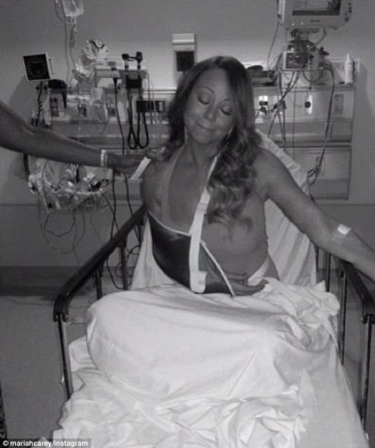 Mariah Carey posing in her hospital bed after dislocating her shoulder following an accident on the set of her new music video clip