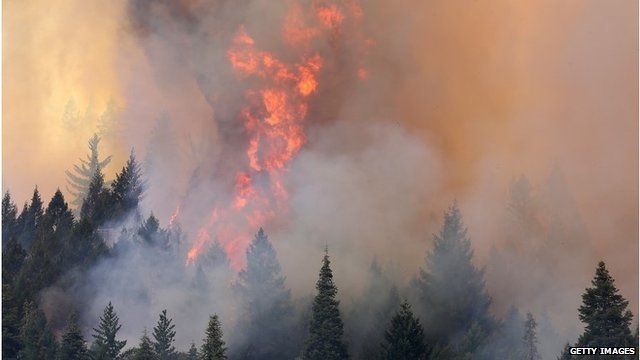 Yosemite Park blaze has forced scores of tourists to flee during peak season and is threatening thousands of homes