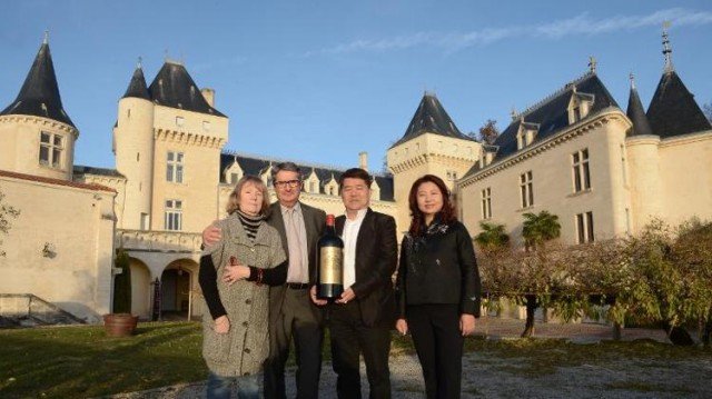 Lam Kok and James Gregoire pictured with their wives while celebrating the sale of the chateau 