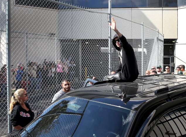 Justin Bieber walked out of the Turner Guilford Knight Correctional Center surrounded by police and climbed atop his waiting SUV