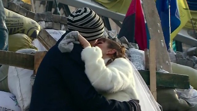 The newly-married couple has climbed to the top of a protest barricade in Kiev to celebrate their wedding