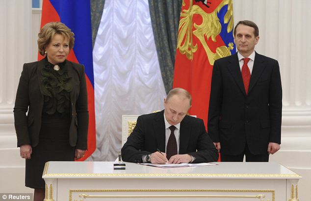 Vladimir Putin has signed a law formalizing the takeover of Crimea from Ukraine