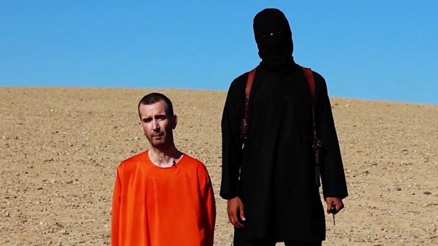 Masked ISIS militant pictured beside David Haines