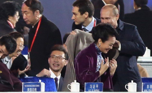 Vladimir Putin carefully placed a shawl over the shoulders of China's stylish first lady Peng Liyuan